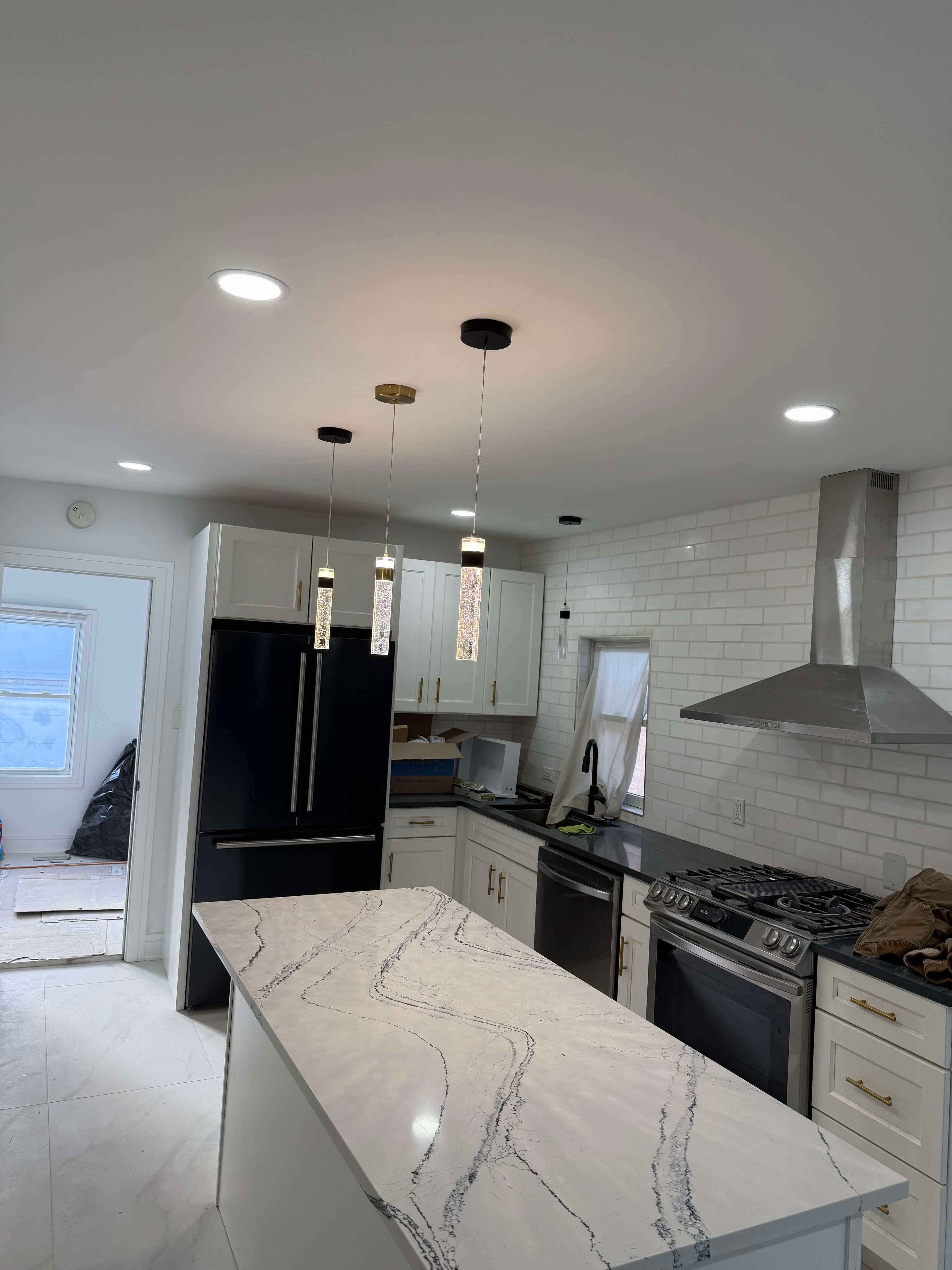 Compact kitchen remodel with white cabinets and stainless appliances