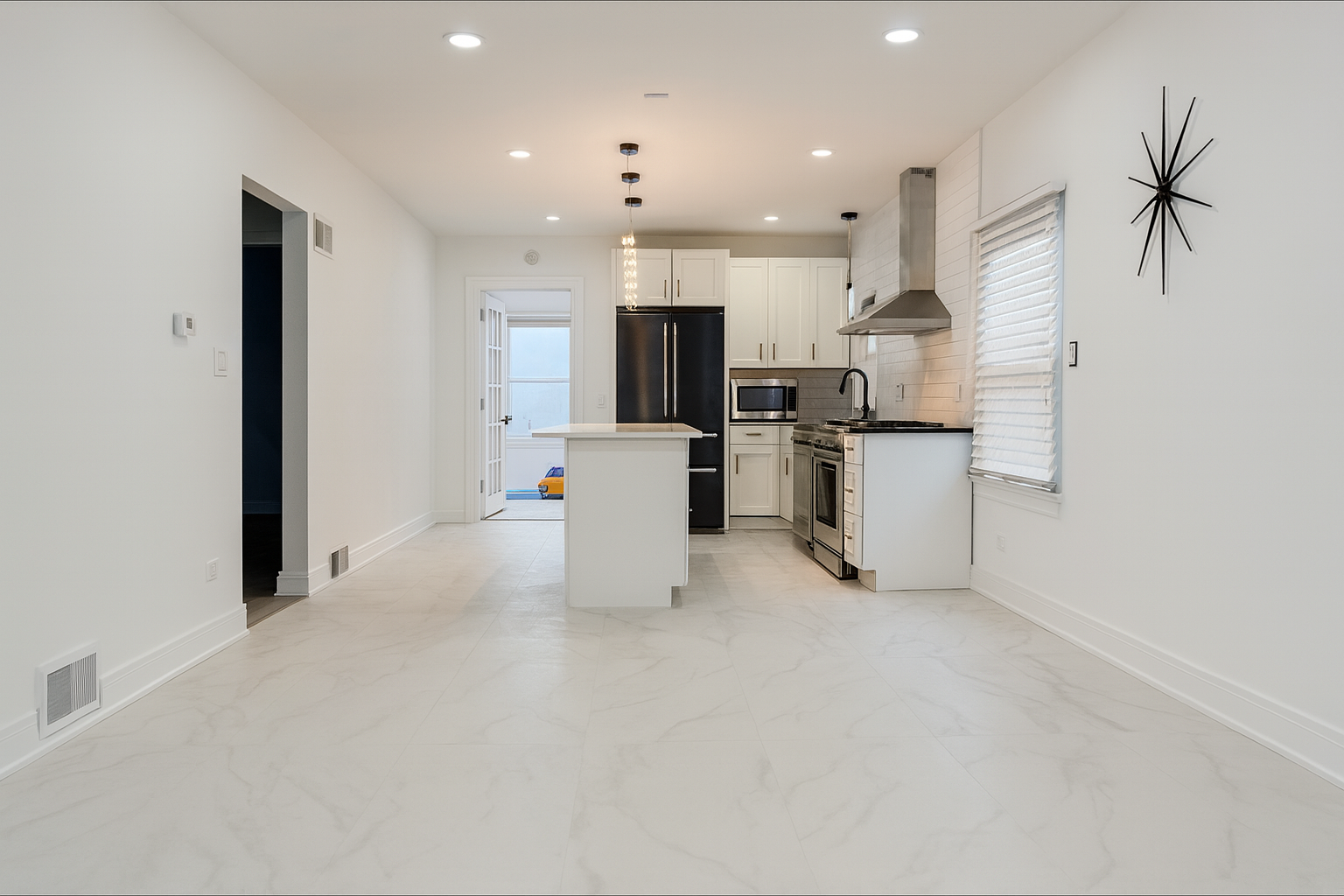 Remodeled kitchen with island and pendant lights by Remodel Right Restorations